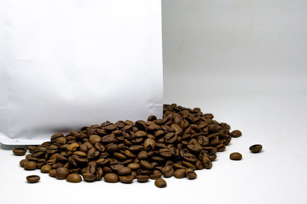 custom coffee pouches beside coffee cup for format planning